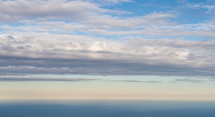 Obraz premium Calm Water Reflecting Cloudy Sky Creates a Serene Coastal Scene