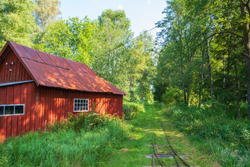 Old red shed at a narrow-gauge railroad in the woodland
