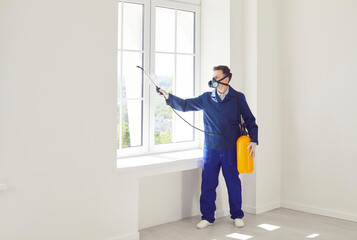 Man worker from the pest control service using equipment, diligently sprays pesticide or insecticide to eliminate insects, bugs or termites, ensuring a pest free environment in the home.