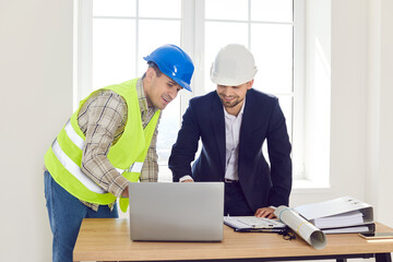 Engineer colleagues meeting looking at project online, blueprints, planning work, renovation....