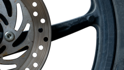Partial view of a motorcycle wheel and brake disc against a white background. Metal disc has drilled holes and the tire textured surface is visible.