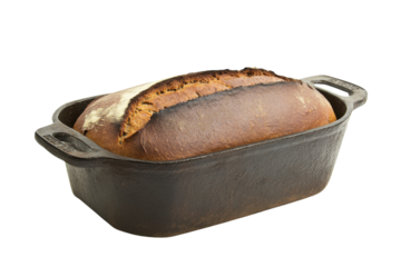 Freshly baked artisan bread cooling in a rustic cast iron pan on a wooden kitchen countertop isolated on transparent background