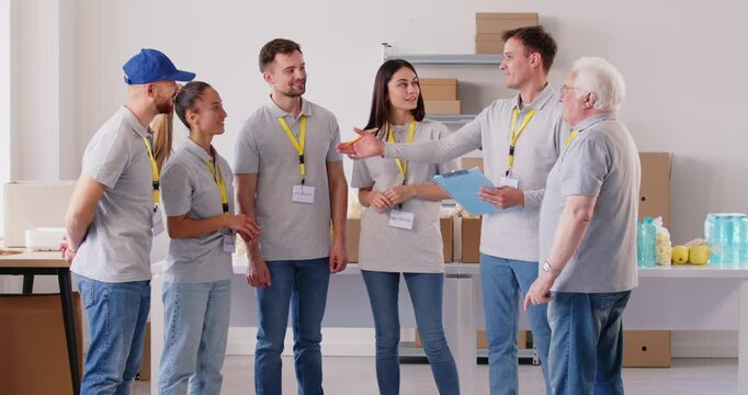 Diverse volunteer team engaged in meeting before starting work at a social assistance center or charity organization office. Dedication to community, social work, and humanitarian help.