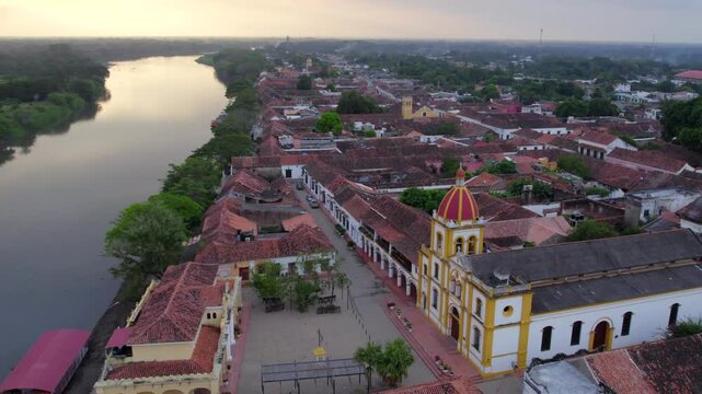 As the town's historic charm unfolds below, the majestic Church of Mar&iacute;a Inmaculada comes into view, its elegant facade standing as a testament to time. Beyond. The vast Magdalena River