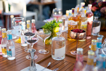many different ingredients on the bartender's table for making alcoholic cocktails