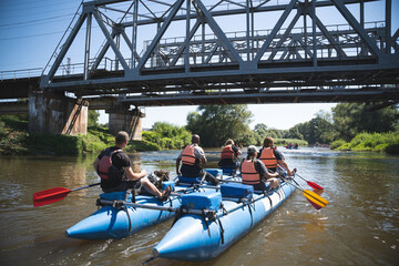 a team of athletes on a catamaran overcomes obstacles floating on the river