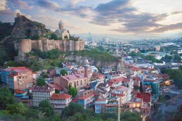 Fototapeta premium Landscape of old town Tbilisi and Metekhi Church on the background of spectacular blue sky with clouds