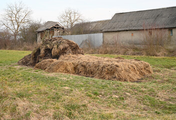 Haystack positioned in a rural landscape near an old barn