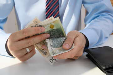 Mężczyzna trzyma w dloni pieniądze  w gotówce, liczyć banknoty 