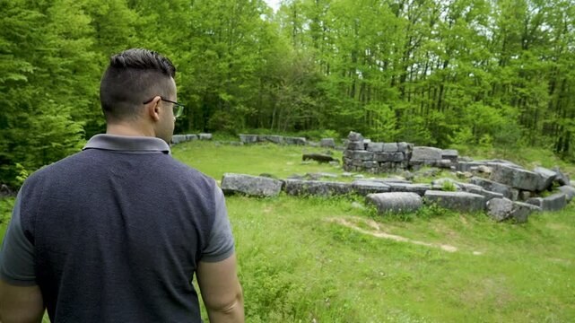 A lone tourist walking towards the ancient ruins of Mishkova Niva Tomb located near Malko Tarnovo by the Strandzha Mountains in Bulgaria.