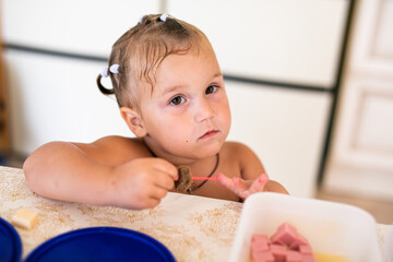 Toddler girl enjoying food in kitchen