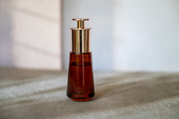 Anti-Age Eye Face Serum in Glass Bottle on a shadows background 