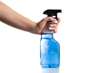 Bottle with blue liquid spray for washing car windows in hand on white background, close-up