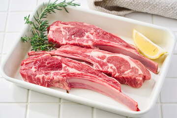 白いバットに並べた生のラムチョップ肉