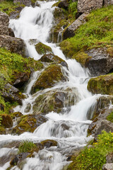 Creek flowing on a green rocky hill. Seydisfjordur area. Iceland.
