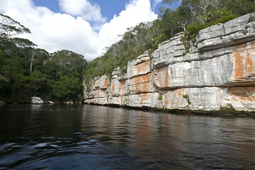 A scenic view of a river with rocky cliffs and trees
