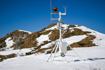 Automated weather station collecting meteorological data in a snowy mountain environment, highlighting climate research and environmental monitoring