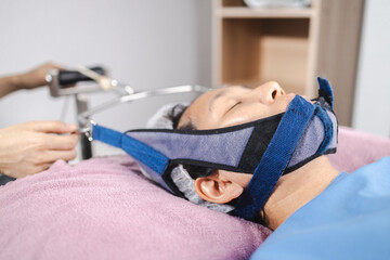 traction neck therapy, physical therapy, person receiving neck therapy in physical therapy session,...