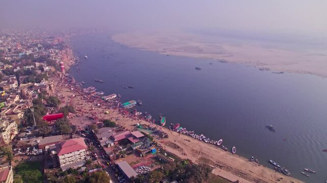 aerial view of assi ghat with ganga river and boats at banaras, varanasi, kashi, uttar pradesh, india. day time, moving down, drone shot, 4k.