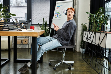Focused young professional in a modern office with headphones engaged in work activities