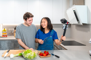Young couple recording cooking show in kitchen