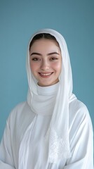 A beautiful young woman wearing a white headscarf smiles