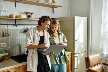 Young couple enjoying quality time together while working in their cozy modern kitchen