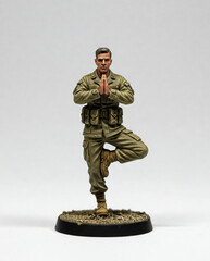 Miniature soldier figure in military uniform balancing on one leg with hands in prayer position, on a textured circular base. 