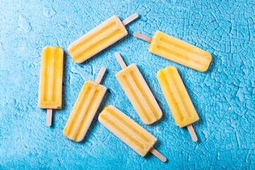 Yellow popsicles on blue background