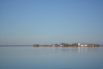 Naklejka premium Fraueninsel, Frauenchiemsee on lake Chiemsee in the morning sunrise with boat, Sailboat, church, monastery. Bavaria, Bayern, Germany