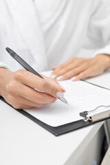 Writing notes on a clipboard in a bright workspace during the day