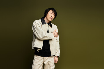 Stylish young man posing confidently in modern studio setting with green backdrop