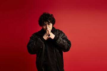 Mysterious contemplation, studio portrait of asian man in black outfit