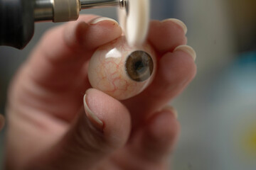 Ocularist polishing an ocular prosthesis with a rotary tool