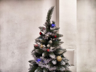 Christmas tree adorned with ornaments and lights in a cozy indoor setting during the holiday season