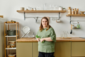Young woman with Down syndrome showcases her confidence at home while holding fresh vegetables