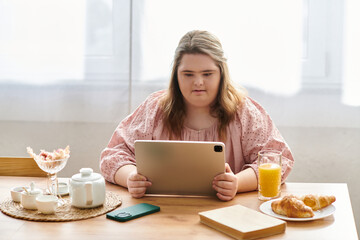 Confident young woman with Down syndrome enjoying cozy moments at home with a tablet