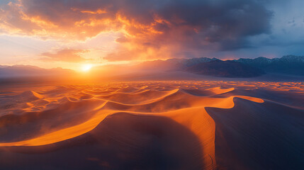 Sunset over rolling sand dunes in a desert landscape