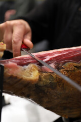 experto del corte de jamón ibérico cortando una loncha de jamón con un cuchillo jamonero