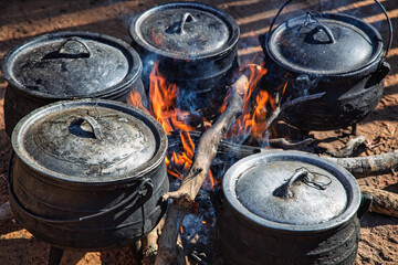 three legged pot cauldron , cooking food outdoors, , African village , at an event, food security...