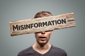 Misinformation sign in front of a person's face 