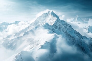 Majestic snow-covered mountain peak rising above clouds during a clear winter day in the wilderness