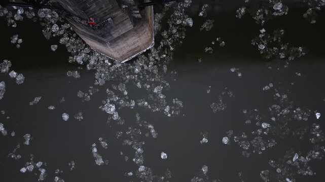 Sheets of ice can be seen flowing under the Eads Bridge connecting Illinois to St. Louis, Missouri. The ice is slowly collecting around the feet of the bridge.