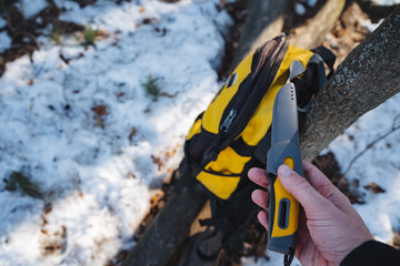 This scene embodies outdoor exploration a hand with a utility knife beside a bright yellow...