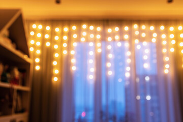 Blurred picture of warm, inviting bokeh lights garland across a curtain, creating festive ambiance....