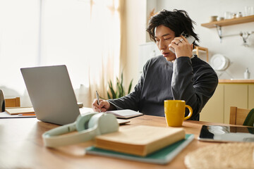 Fototapeta premium Studying online at home, a focused young man engages in e-learning at his desk