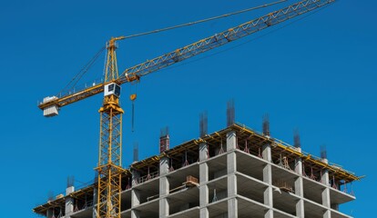 Construction crane lifting materials at building site in urban environment. Represents development and infrastructure growth.