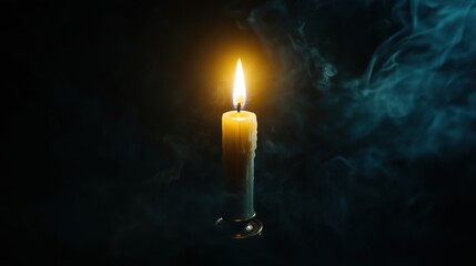 Glowing candle in darkened atmosphere with wisps of smoke