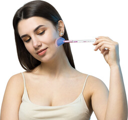 Close-up of a young girl in a light top on a white background making a facial make-up. A pretty...
