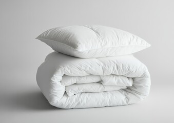 Folded white comforter and pillow on gray background